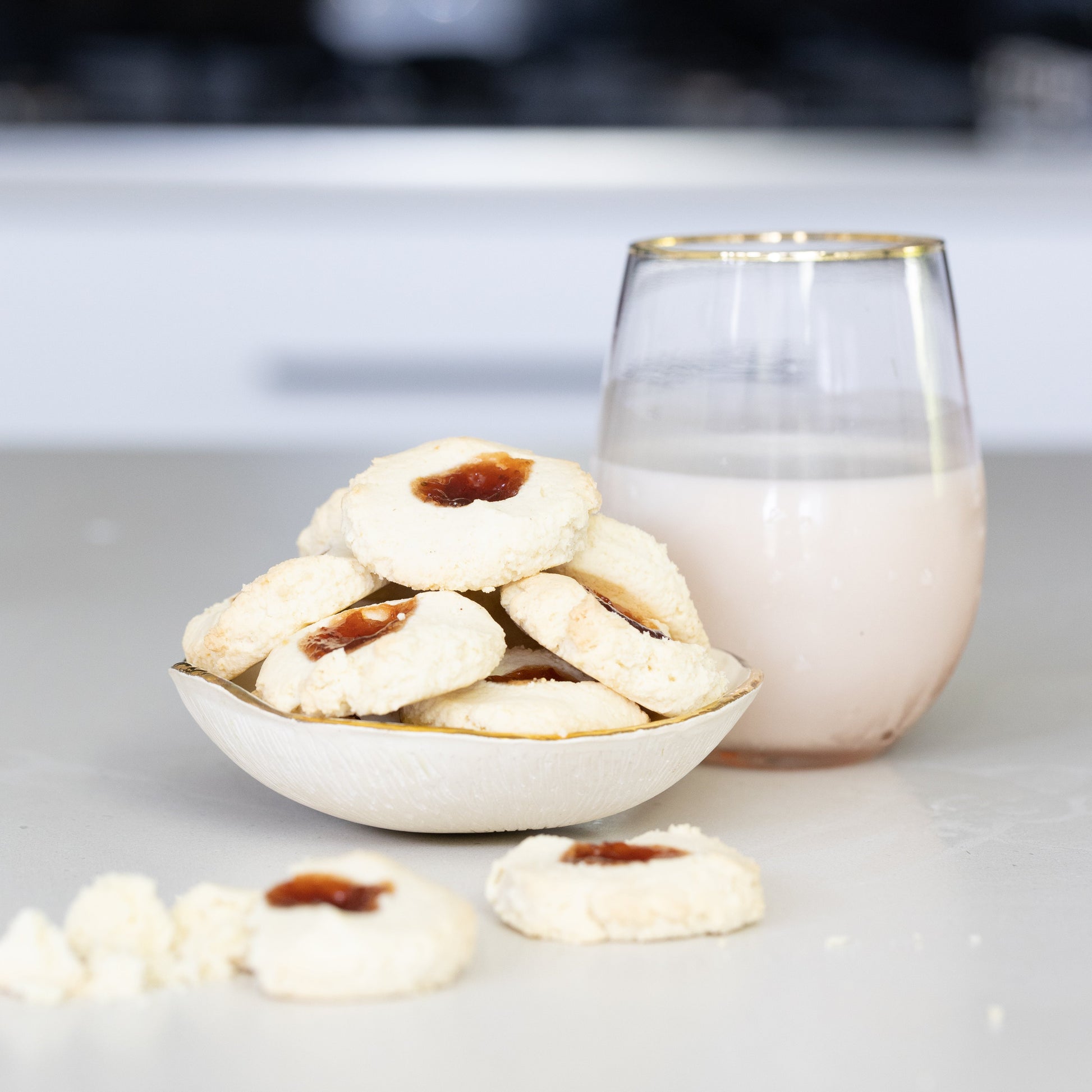 gluten free cookies in a bowl with a glass of milk on a kitchen counter